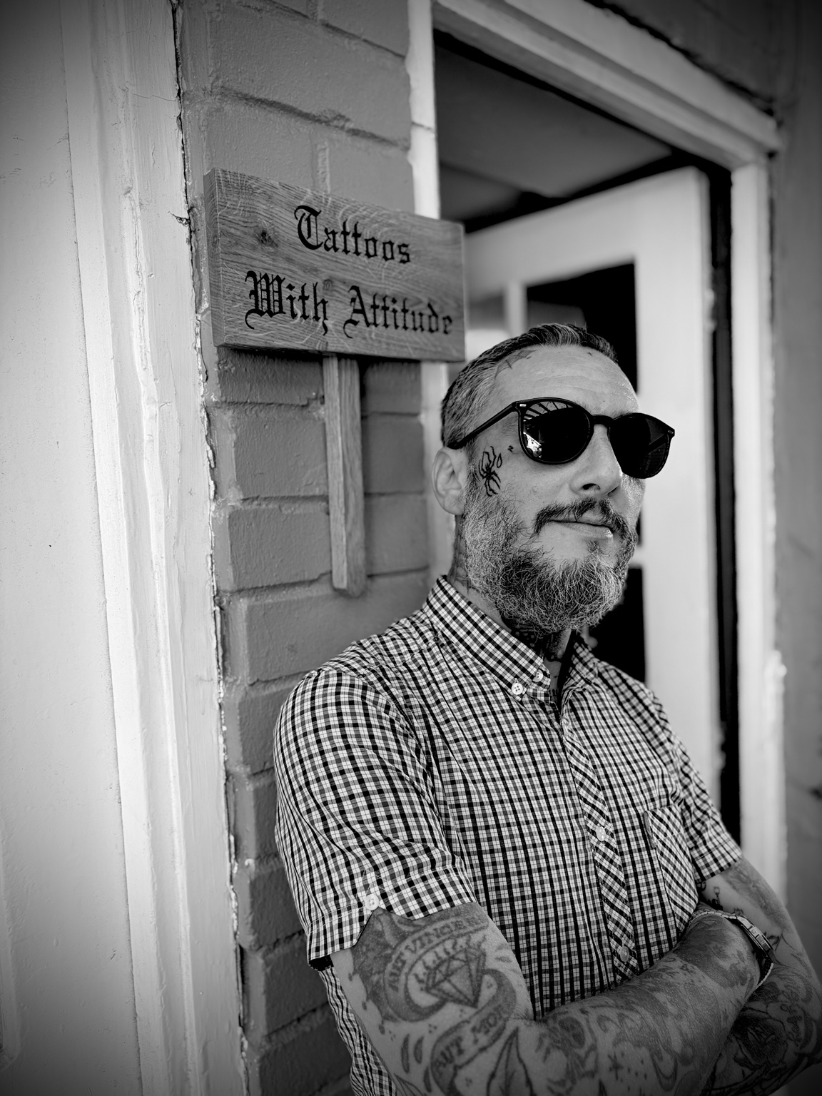 Alessandro outside the studio beside the Tattoos With Attitude sign